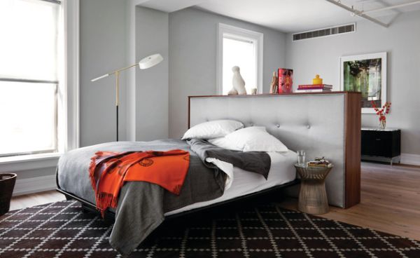 Bachelor pad uses a tufted headboard to demarcate the bedroom area