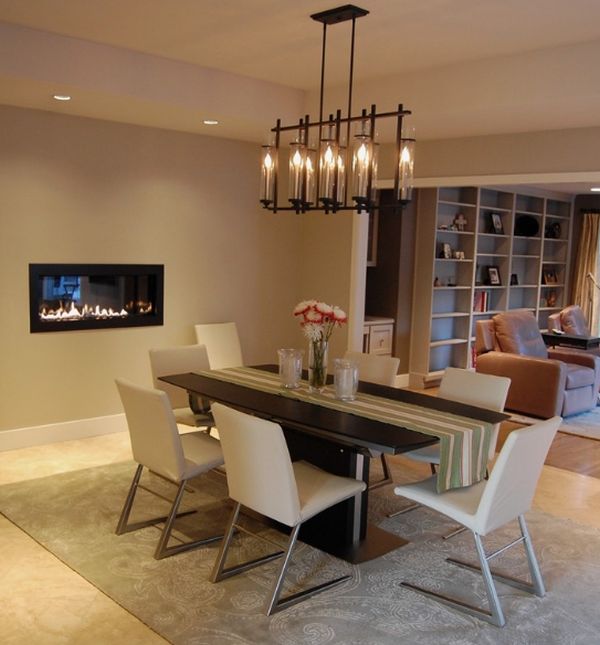 Chandelier above the dining table complements the fireplace stylishly