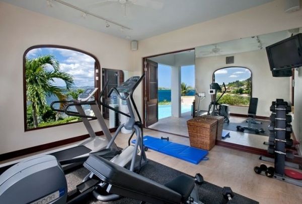 Large glass windows visually connect the home gym with the canopy outside