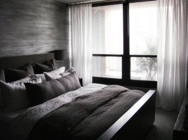 Minimalist bedroom in dark colors and contrasting white drapes