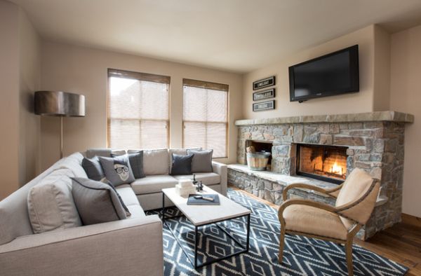 Patterned rug and a stone fireplace give this bachelor pad a cozy and classic vibe