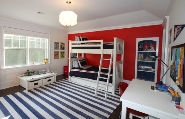 Red accent wall makes an interesting addition to this kids' bedroom