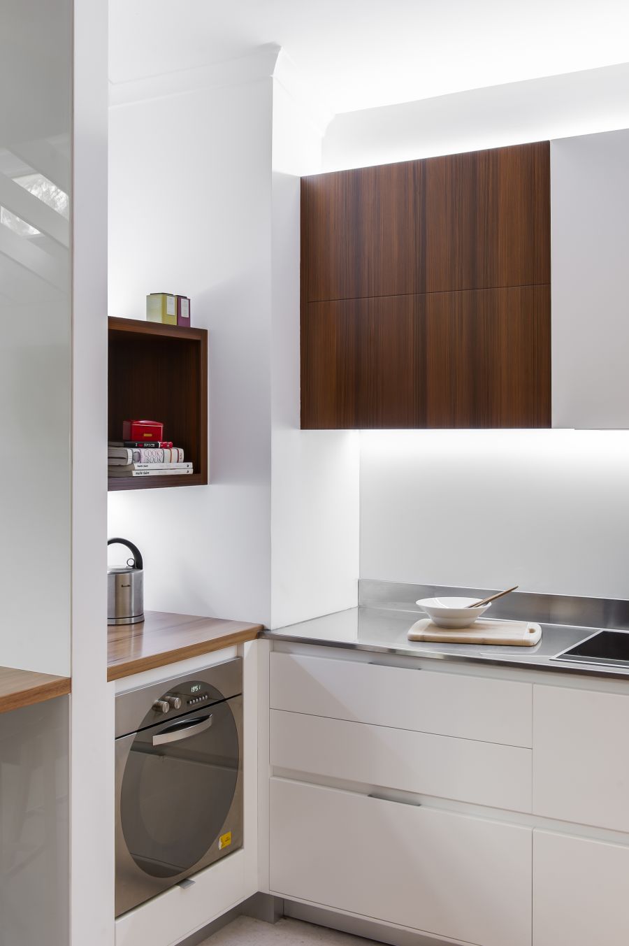 Rich reddish timber veneer adds warmth to the kitchen