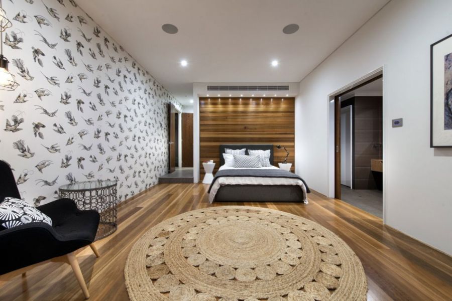 Warm wood accents and interesting wallpaper in the bedroom