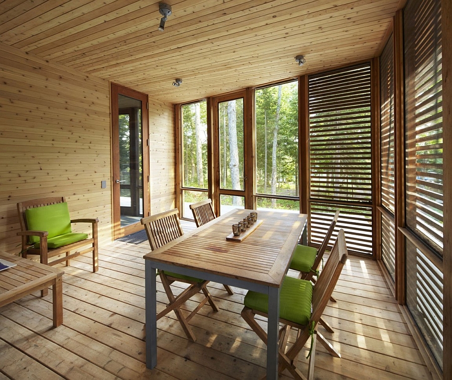 Large glass windows offer views of the woods from the cabin
