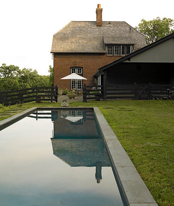Observe how elegantly the pool reflects the facade of the country home