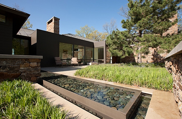 Small reflective pool in the backyard with rounded cobbles
