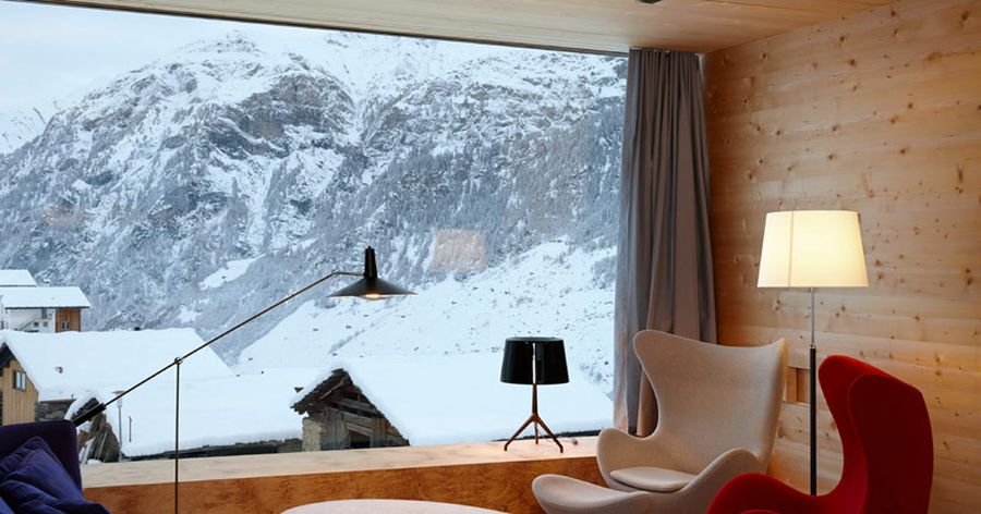 large glass windows offer views of snowy ski slopes