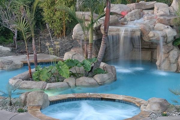 A hot tub and waterfall feature add to the grandeur of your backyard pool