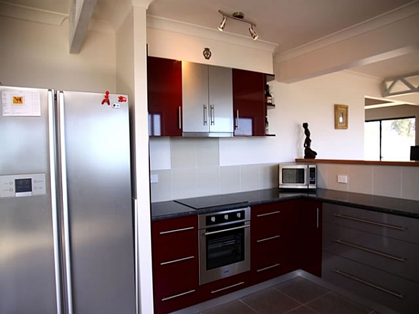 Contemporary kitchen with colorful red shelves