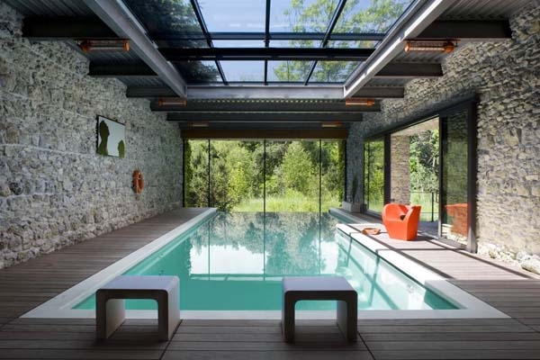 Indoor pool with stone walls and glass roof