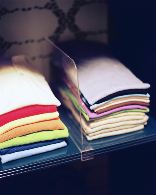 Neatly folded shirts in an organized closet