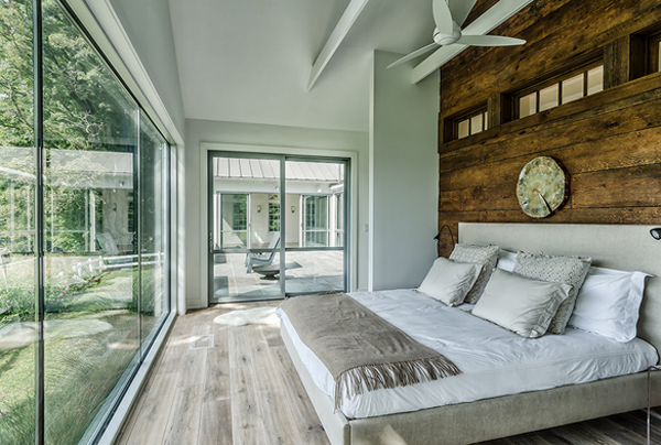 Modern rustic bedroom with large windows and ceiling fan