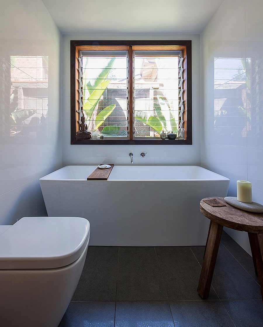 Bathtub in white next to the window