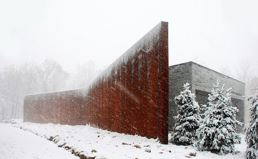 Curved Corten wall protects the house from the elements