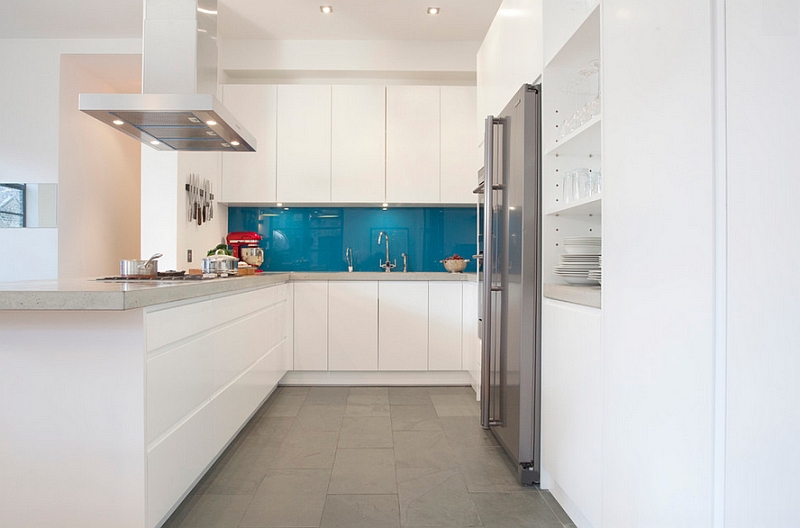 Grey concrete worktops combined with peacock blue splashback