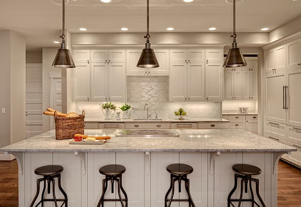 Metal pendant lights above the kitchen counter stand out thanks to the neutral backdrop