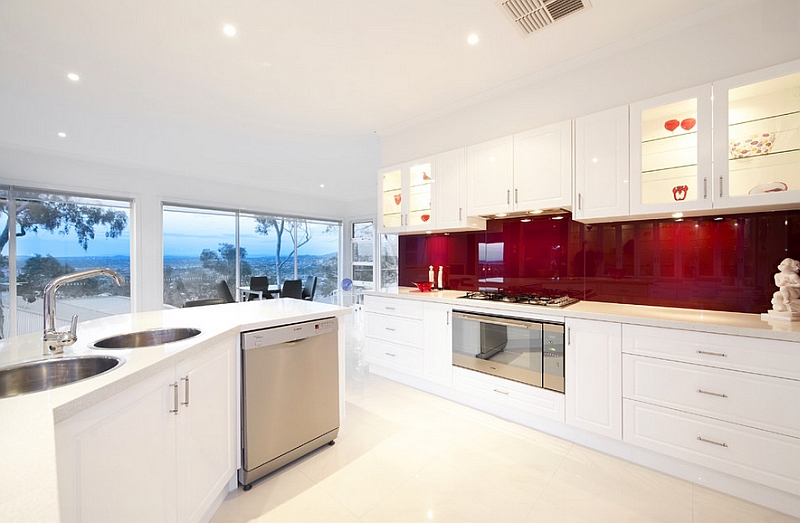 Posh contemporary kitchen with red backsplash