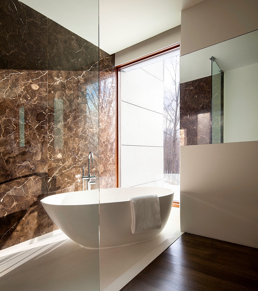 Standalone bathtub next to the glass window