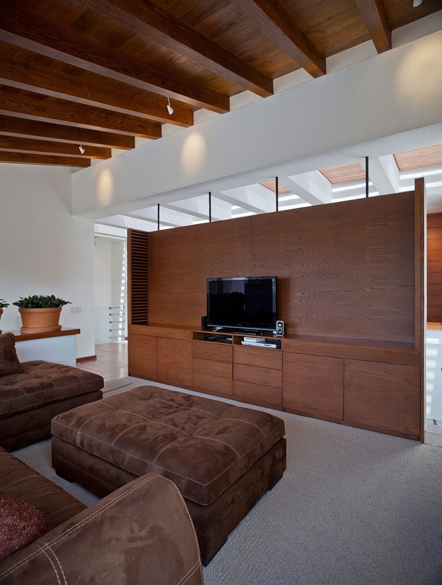 Wooden ceiling and large entertainment wall add warmth to the space