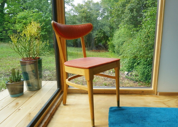 A Mid-century chair sits in the window