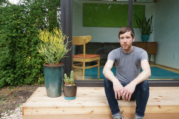 Andy Pluta in front of the tiny house he built in his backyard