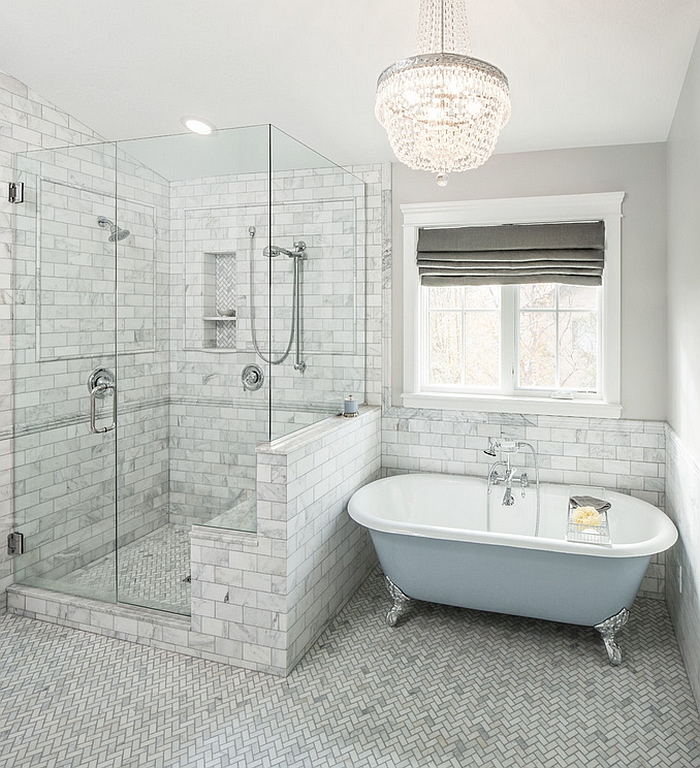 Bathroom in soft grey and blue with herringbone floors and a painted bathtub