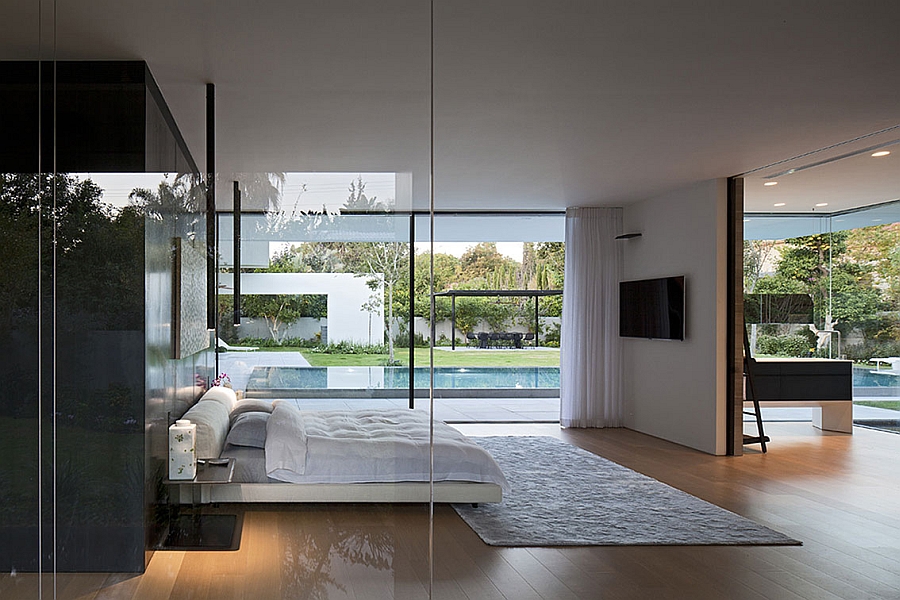 Frameless glass walls and doors connect the bedroom with the courtyards
