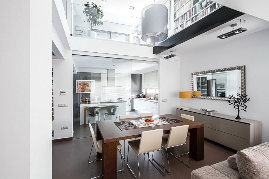 Frameless sliding glass doors between the kitchen and dining area