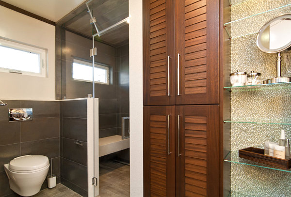 Glass shelving in a rich-toned powder room