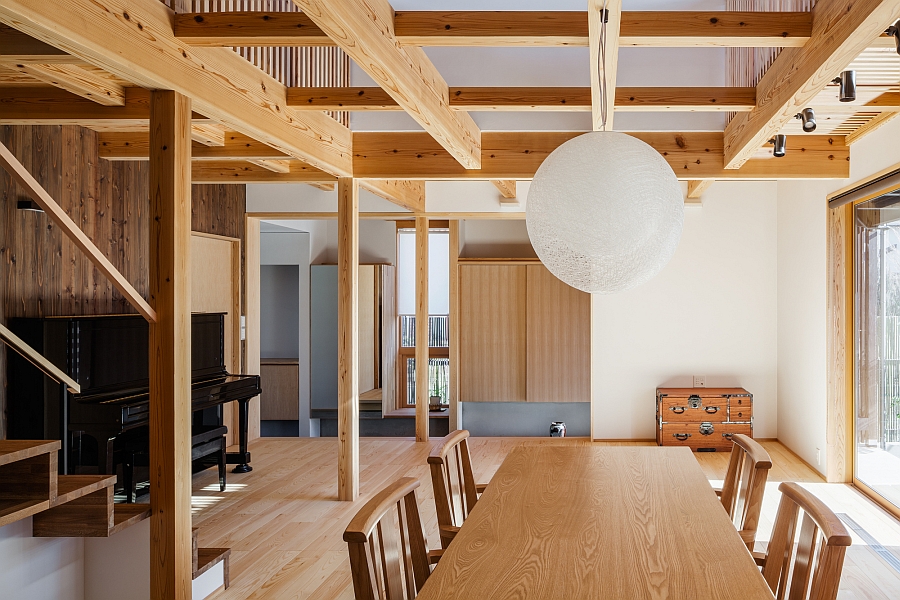 Globe pendant in white above the wooden dining table