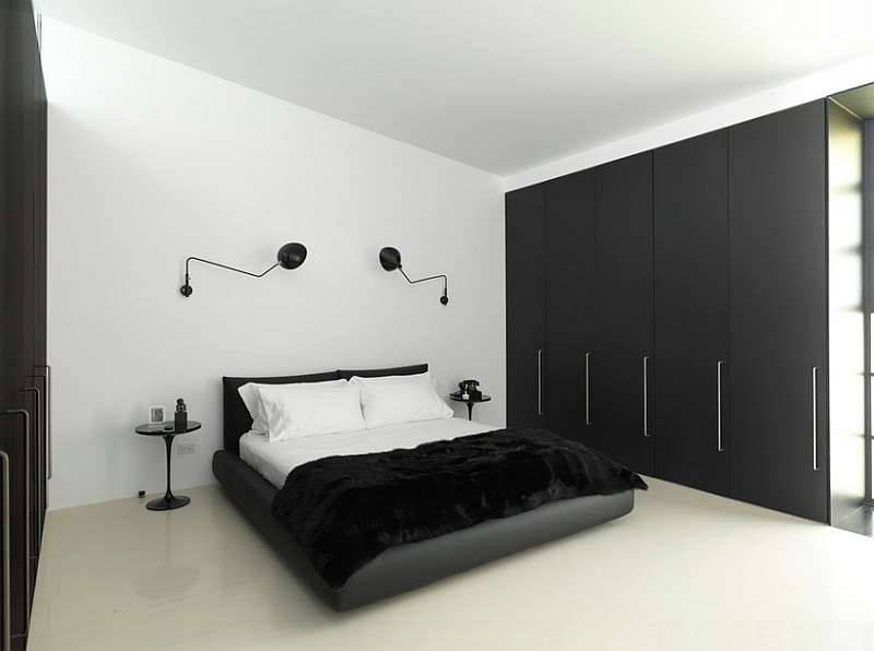 Minimal bedroom in black and white with wall sconces and Tulip side table