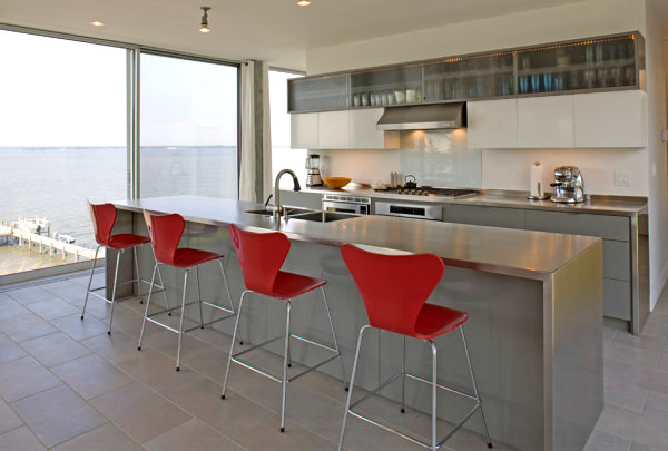 Red chairs brighten a kitchen with stainless steel countertops