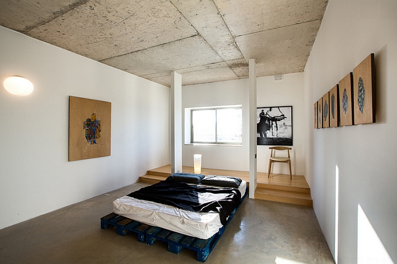 Rough concrete ceilings, walls and beams add industrial charm to the minimal bedroom