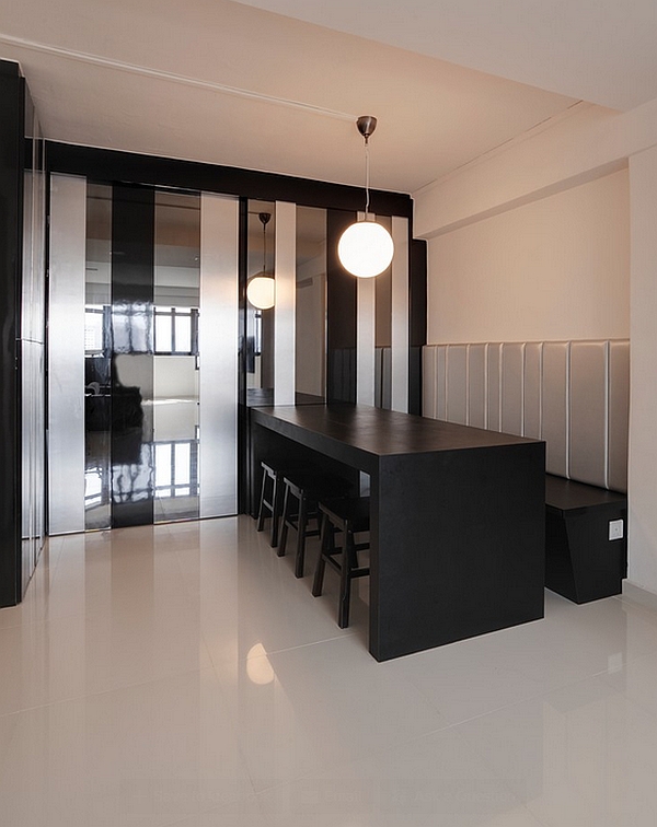 Sleek minimalist dining space with a black table and bench seating