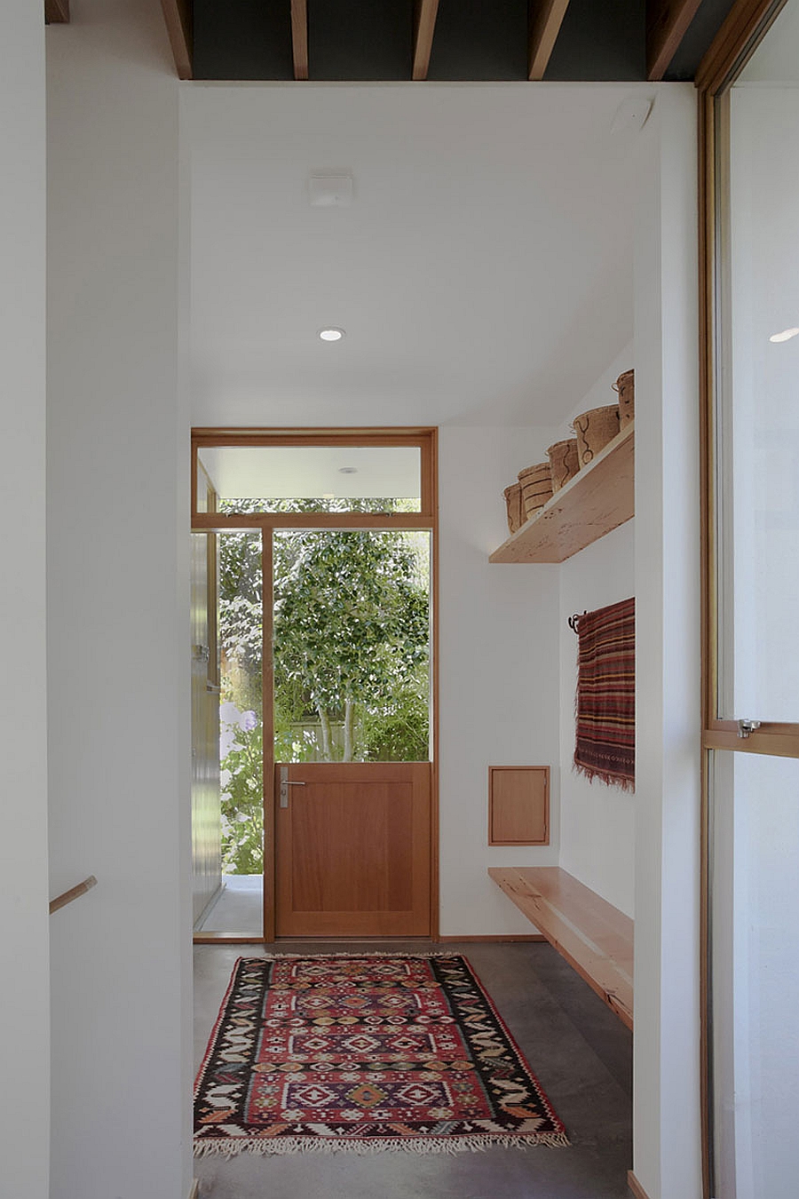 Small mud room idea with a rug and floating shelves