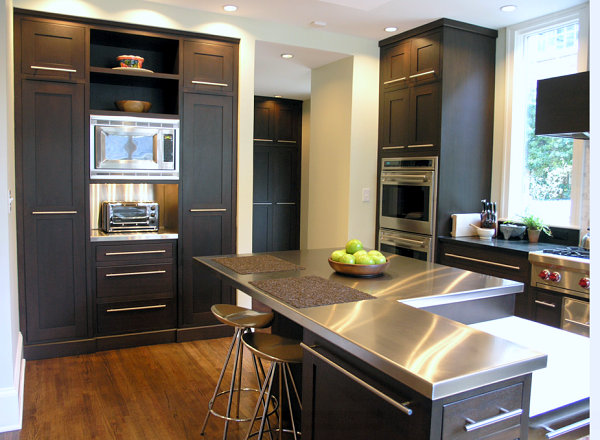 Stainless steel countertops brighten a kitchen with black cabinetry