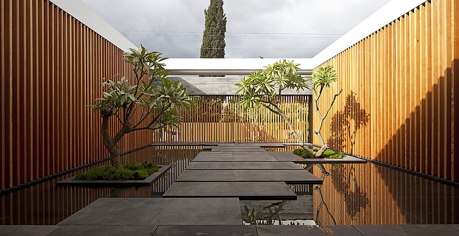 Stunning entryway idea with wooden slats, reflective pools and basalt rock