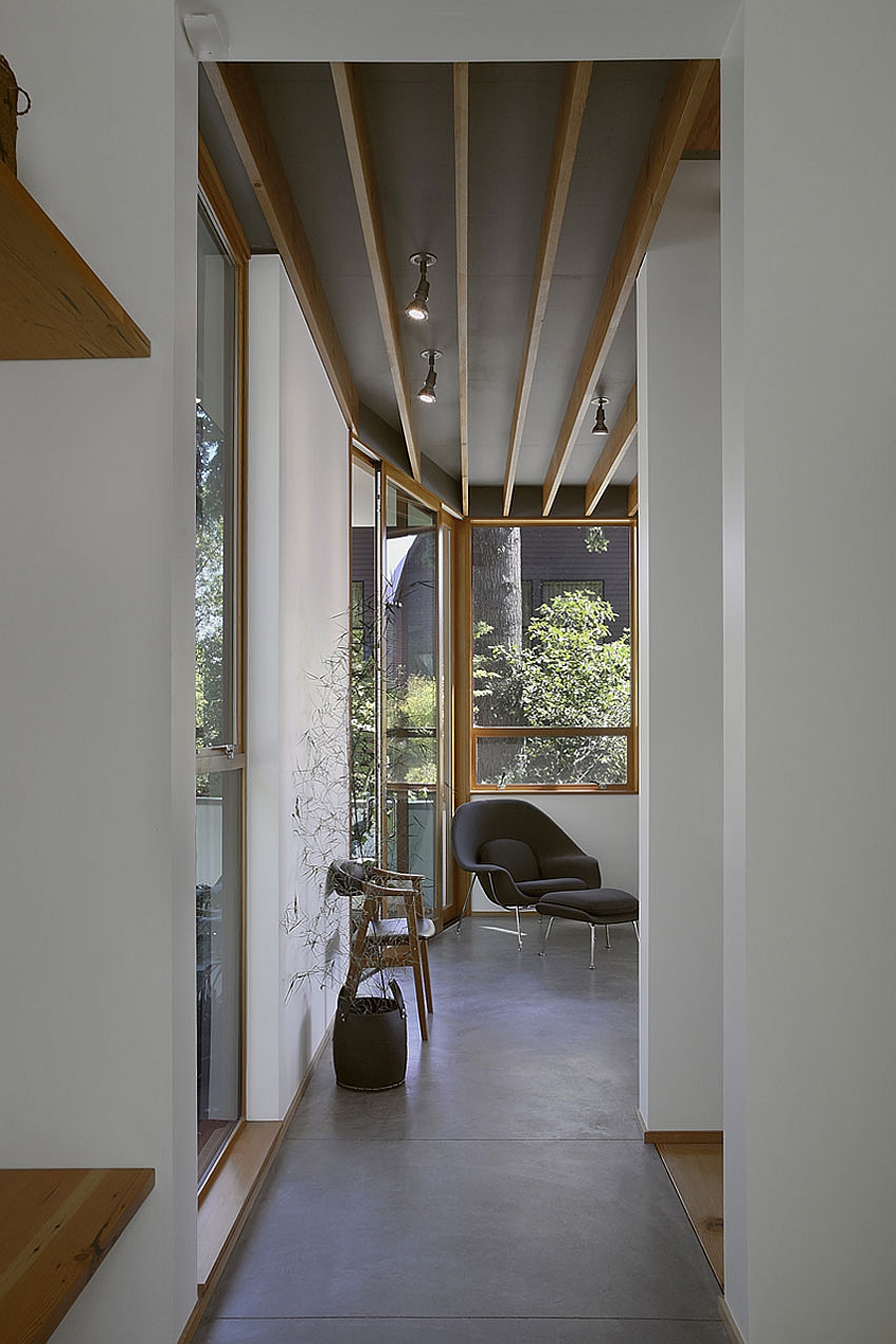 Track lighting and the Eero Saarinen Womb Chair inside the house