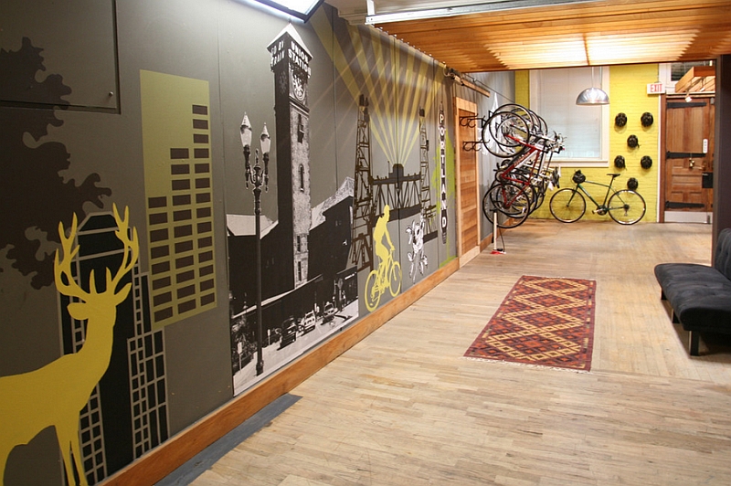 An industrial style entry with a bike rack, barn door and an attractive wall mural