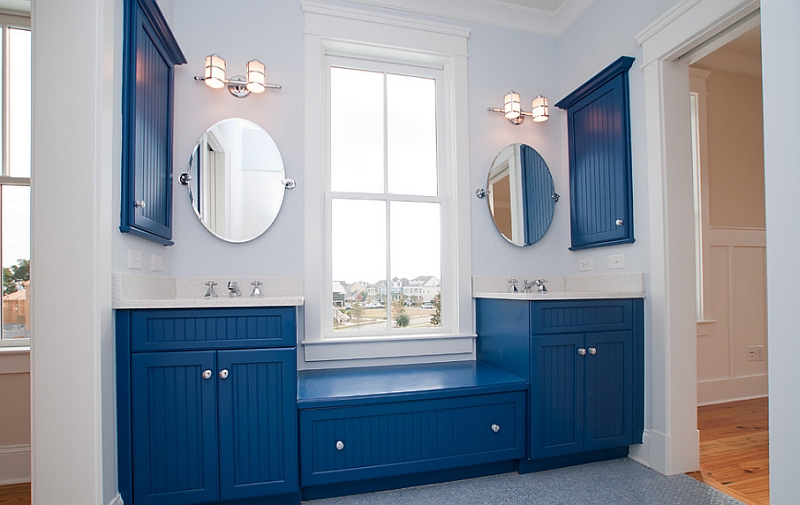 Bathroom cabinets in blue give the space an eclectic appeal