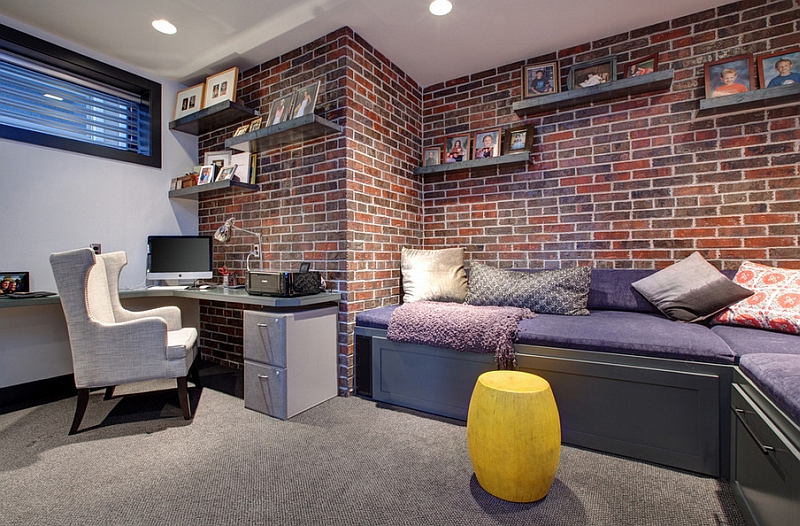 Contemporary basement home office with a brick wall