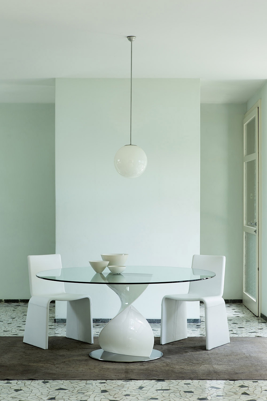 Contemporray dining table with white sculptural base and glass top