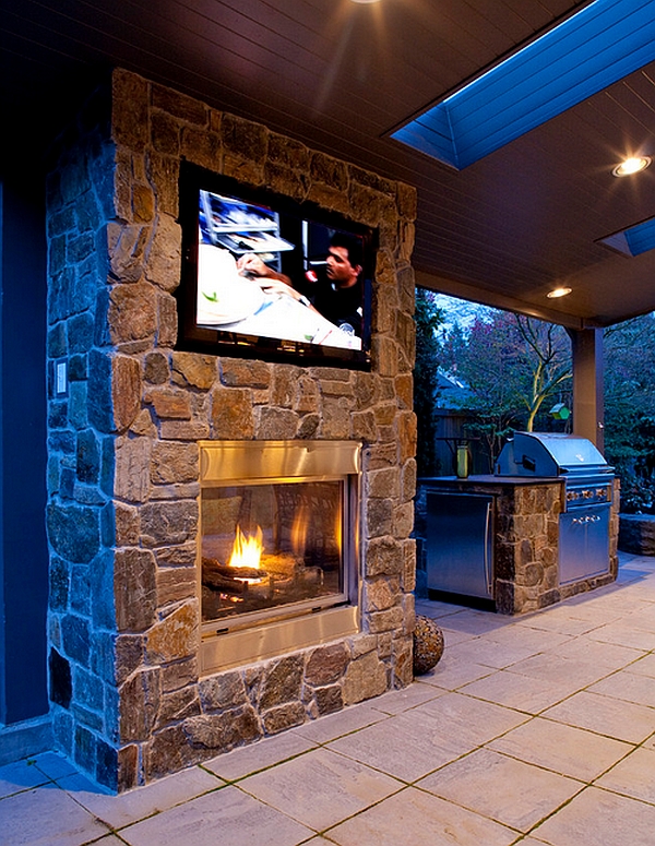 Double-sided fireplace with wall mounted television in the patio