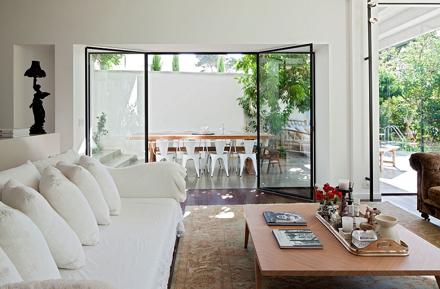 Living space in white connected to outdoor dining area