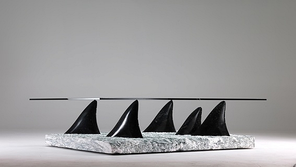 Smart side table with glass top and base shaped like dolphin fins