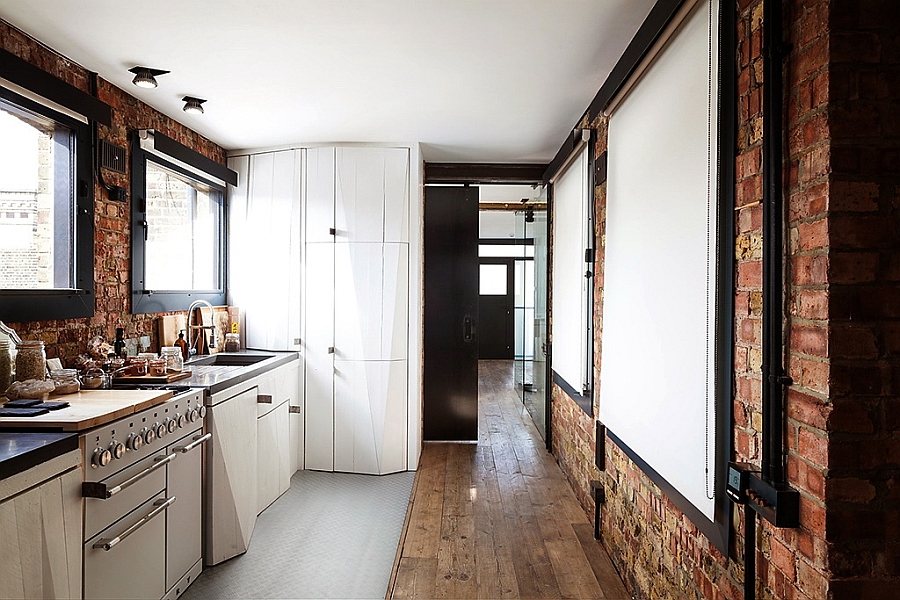 Spacious modern kitchen with exposed brick walls linking the reception and the bedroom