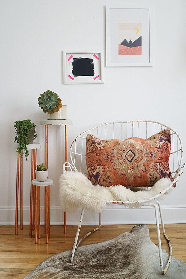 Succulents displayed on concrete and copper plant stands