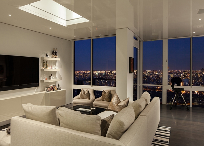 View of the living room at night with the bright lights of NYC Skyline in the backdrop