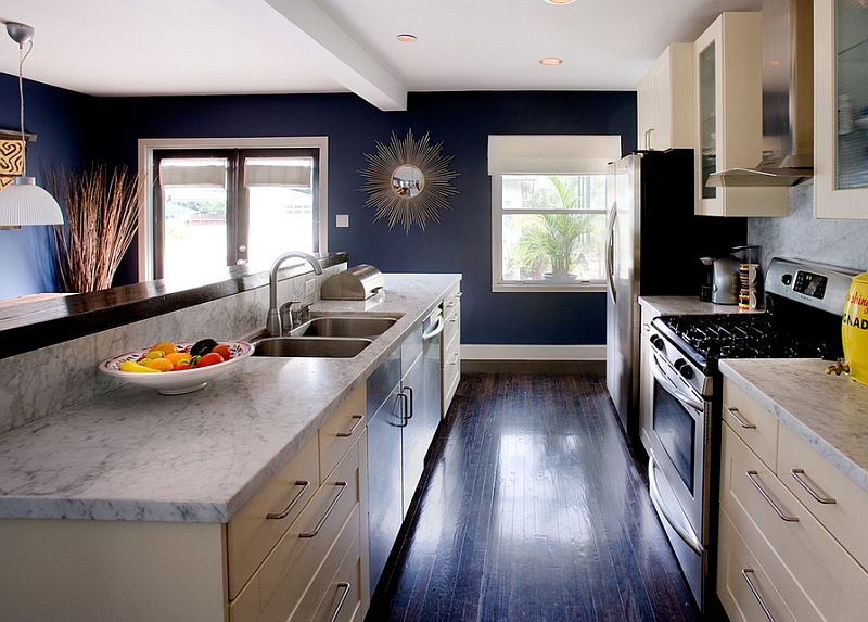 White Carrera Marble, Cream cabinets and Navy blue walls define this trendy kitchen